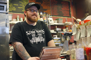 Chris johnson, one of the cafe’s managers, works behind the counter of the newly renovated restaurant. Several items were added to the menu and business has increased.