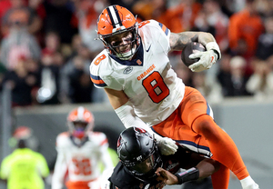 Justin Barron (pictured, No. 8) hurdles NC State quarterback CJ Bailey after returning an intercepted pass in the third quarter of Syracuse's 24-17 win over the Wolfpack.