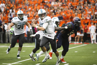 Tulane quarterback Nick Montana scrambles away from the Syracuse pass rush.