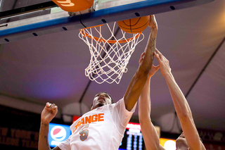 McCullough corrals a ball near the rim with a Colgate player on his back.