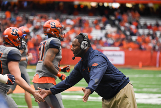 Babers high fives his players as they come off the field. 